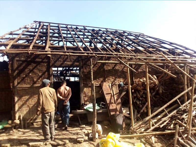 Villagers look on at the remnants of a house that was razed in a fire in Wakching village on November 8. (Morung Photo)